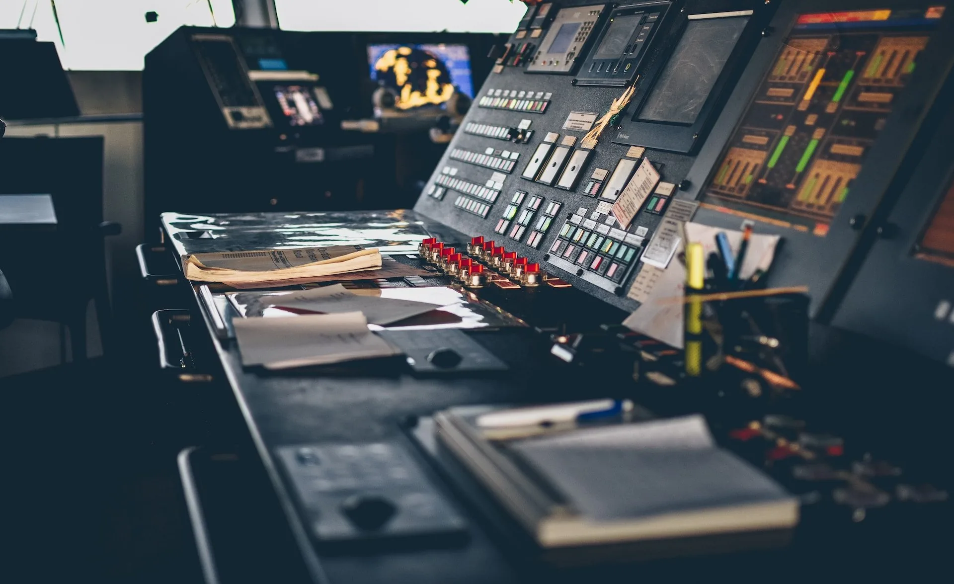 Close crop of a ship's bridge console with paperwork and a navigation instrument