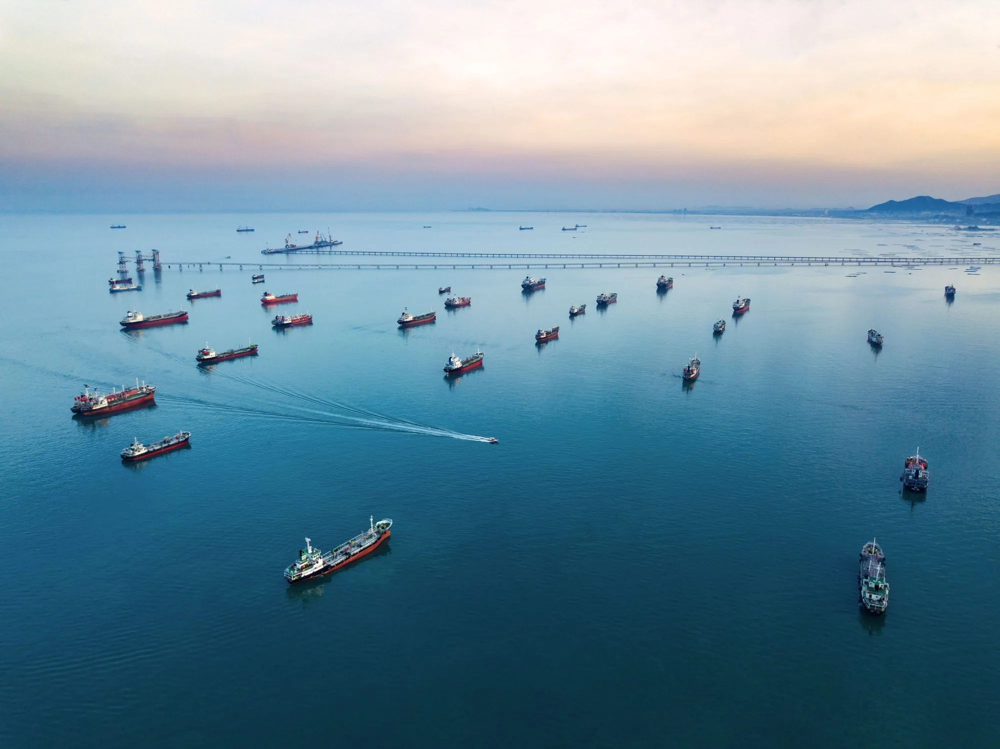 A fleet of ships at anchor waiting in a hazy sea